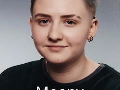 Porträtfoto des 18-jährigen Moony. Kurzes blondes und blaues Haar. Helle Hautfarbe. Piercings im Ohr und in der Nase. Beinahe ein Lächeln. Geboren 22.12.2007, gestorben 26.01.2026.